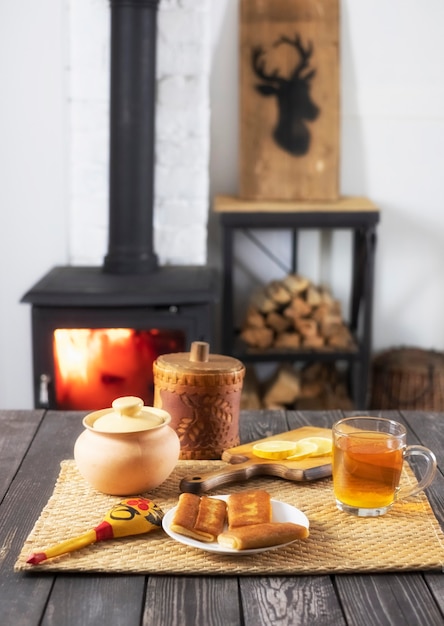 Crêpes fourrées et thé au citron sur une table en bois