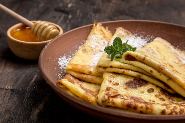 Photo crêpes fraîches au sirop d'érable parfumé et au miel. semaine de crêpes de vacances russe. crêpes au miel ou au sirop