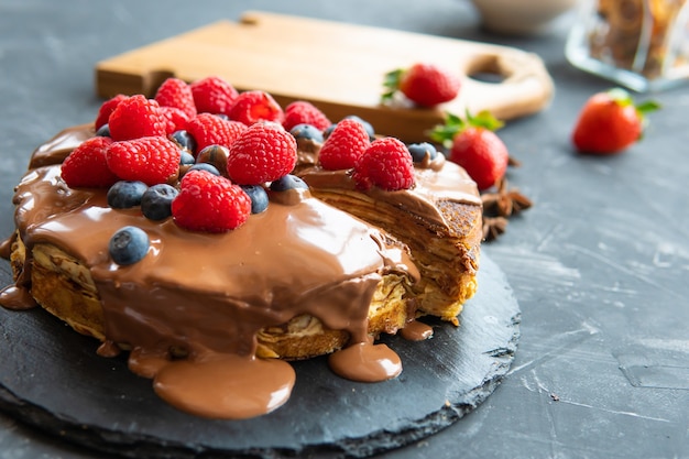 Crêpes avec garniture de dessert et baies sur fond sombre