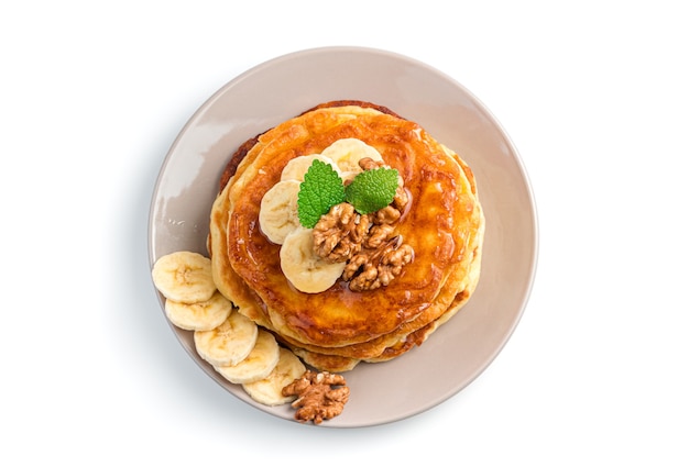 Crêpes maison avec banane, noix et menthe isolées sur blanc. Vue de dessus.