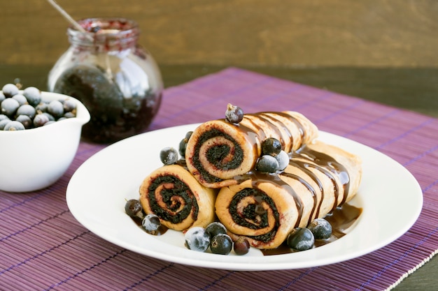 Crêpes maison roulées avec de la confiture de baies fraîches.