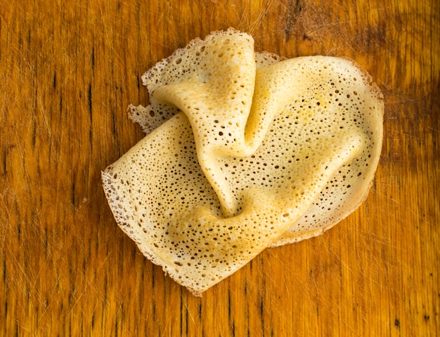 Crêpes minces sur une vue de dessus de fond en bois