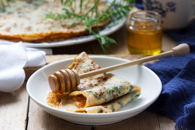 Crêpes à l'ortie et aux épinards servies avec du miel et du café