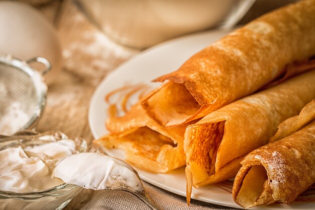 Crêpes roulées sur une assiette avec de la crème sure