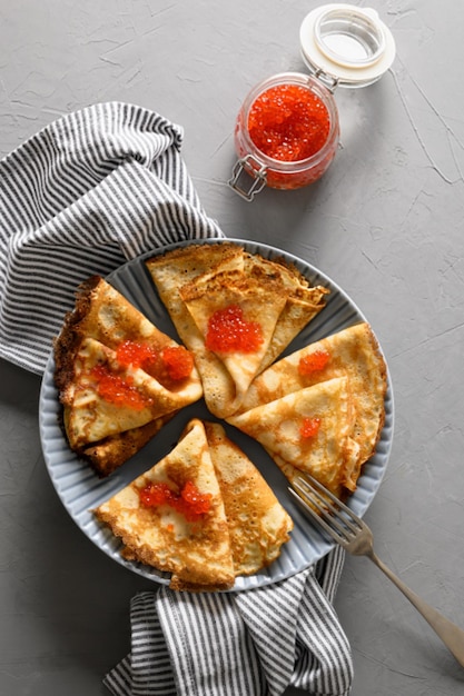 Crêpes russes ou blinis au caviar rouge sur gris