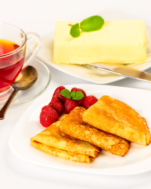 Crêpes russes traditionnelles avec du thé noir et des fraises.