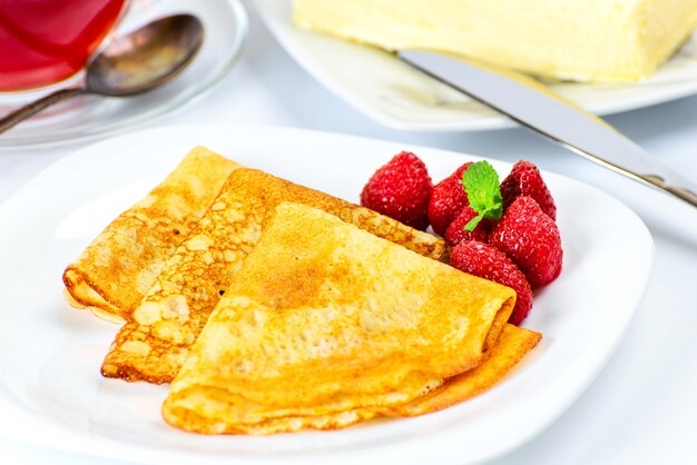 Crêpes russes traditionnelles avec du thé noir et des fraises.