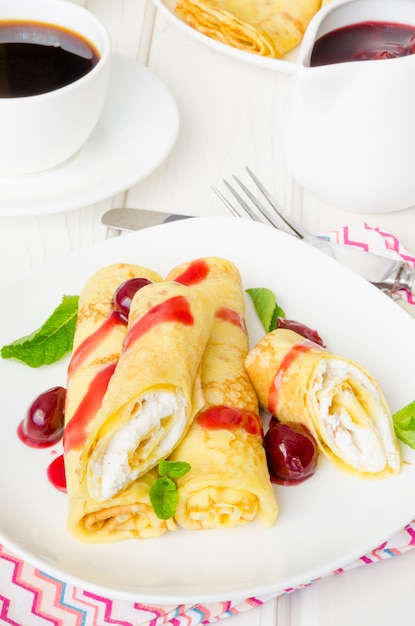 Crêpes russes traditionnelles avec fromage cottage, raisins secs et sauce aux cerises