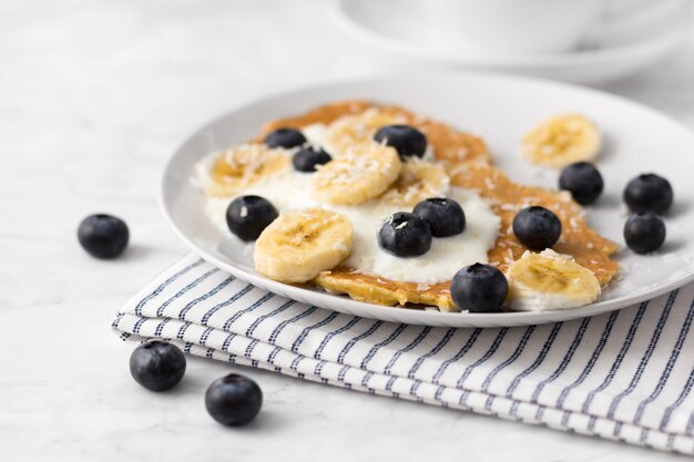 Crêpes saines avec des baies fraîches, des fruits et du yaourt. Concept de petit déjeuner d'été.