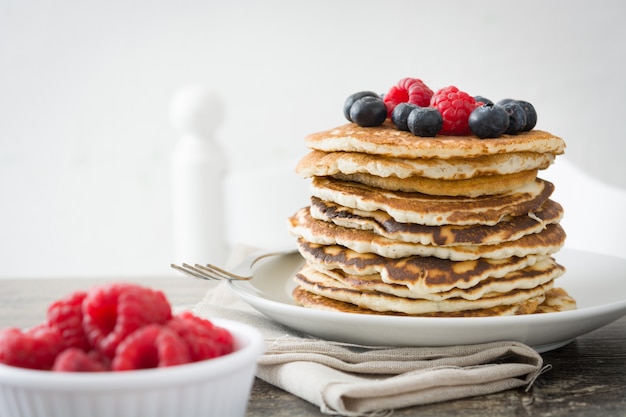 Crêpes sucrées aux bleuets et framboises sur bois rustique