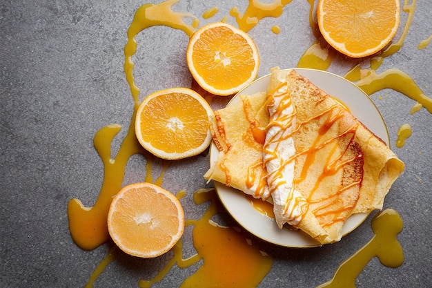 Photo crepes suzette avec fromage à la crème remplie de sauce orange et d'oranges fraîches