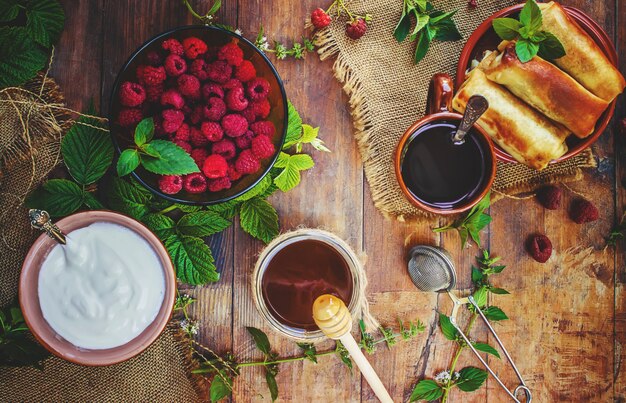 Crêpes et thé sur un fond en bois. Mise au point sélective.