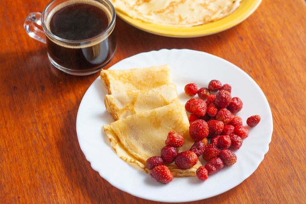 Photo crêpes traditionnelles russes aux baies et café