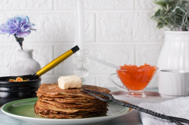 Les crêpes de vacances de Maslenitsa avec de la crème aigre sur la table La tradition russe