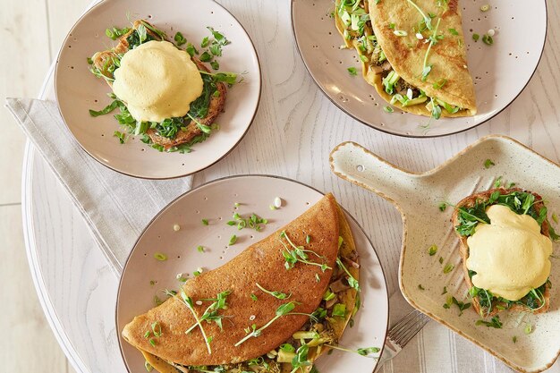 Crêpes végétaliennes aux champignons pousses de pois avocat Oeufs bénédictine avec sauce végétale pain au levain tofu jeune oignon vert Petit-déjeuner sain Vue de dessus nourriture