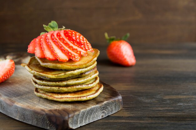 Crêpes végétariennes avec des fraises mûres. sur une table en bois.