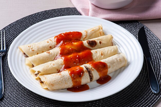 Crêpes à la viande, sauce tomate et fromage