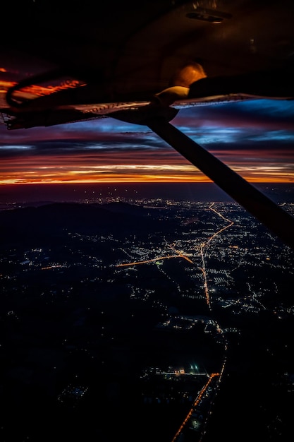 Crépuscule à nuit de l'avion à réaction voir ciel bleu orange rouge avec la lumière de la ville de Thaïlande ci-dessous