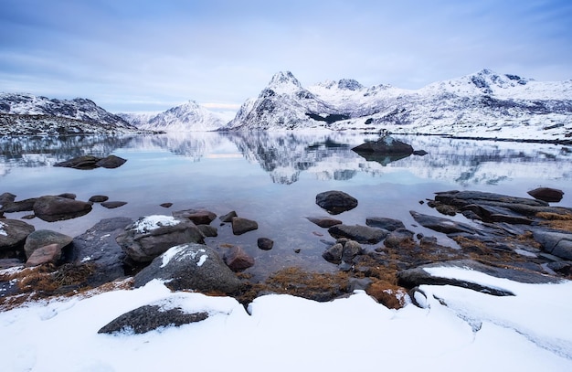 Crête de montagne et glace sur la surface gelée du lac Paysage naturel sur les îles Lofoten Norvège Eau et montagnes au coucher du soleil Image de voyage