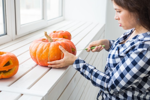 Creuser une citrouille pour préparer une lanterne d'halloween.