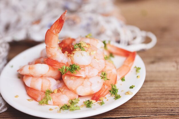 Crevettes à l'ail décortiquées sur fond de plaque blanche nourriture de table à manger, fruits de mer crevettes crevettes fraîches