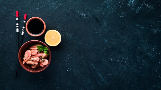 Crevettes au citron dans une assiette sur fond noir Vue de dessus Espace de copie gratuit