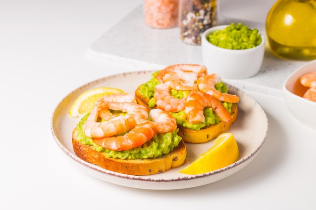 Des crevettes au pain grillé avec de l'avocat et du citron, des crevettes, un concept de petit déjeuner, des bruschettes.