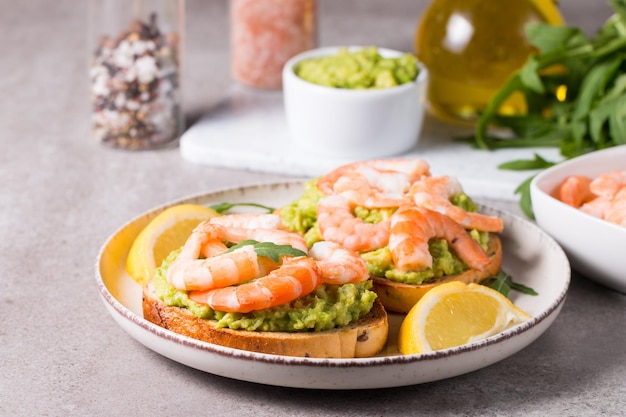 Des crevettes au pain grillé avec de l'avocat et du citron, des crevettes, un concept de petit déjeuner, des bruschettes.