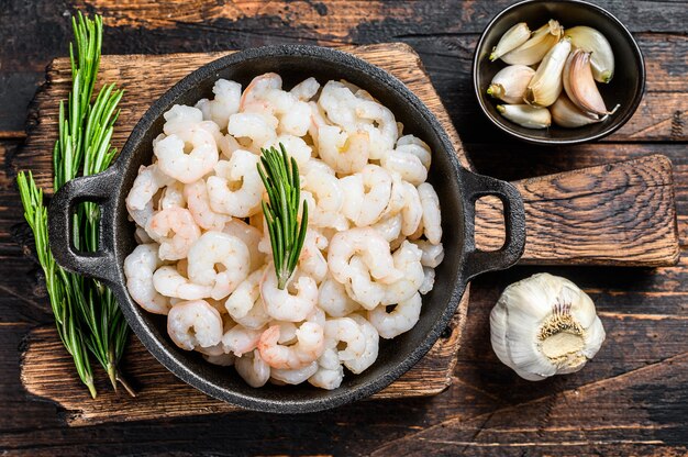 Crevettes Bouillies Décortiquées, Crevettes Dans Une Poêle. Fond en bois sombre. vue de dessus.