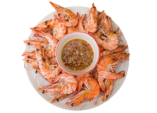 Crevettes bouillies de fruits de mer avec sauce sur plat blanc