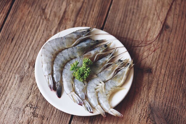 Crevettes crevettes crues sur plaque blanche, fruits de mer de crevettes fraîches pour aliments cuits - vue de dessus
