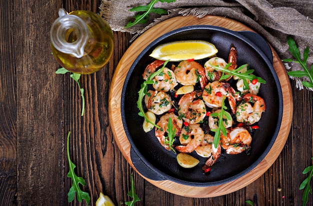 Crevettes Crevettes grillées au beurre à l'ail avec du citron et du persil sur une table en bois. Nourriture saine. Vue de dessus. Mise à plat.