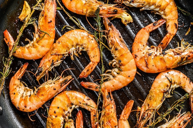 Crevettes, crevettes Plat traditionnel de langoustines frites dans une pâte à l'ail avec du citron et du persil. Nourriture saine. Surface noire. Vue de dessus