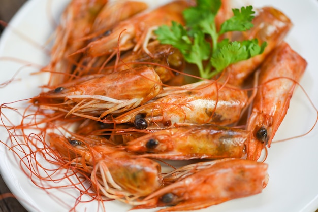 Crevettes croustillantes frites profondes délicieuses épices d'assaisonnement sur plaque et fond de table en bois. crevettes ou crevettes cuites Fruits de mer égoïstes