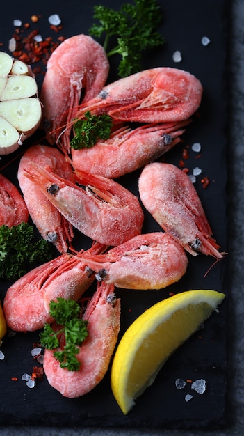 Photo crevettes crues aux épices sur une planche de pierre