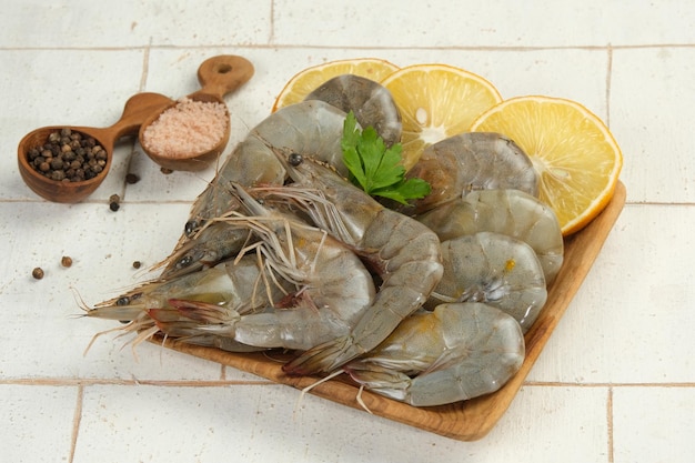 Des crevettes crues dans une assiette avec l'ingrédient sur fond blanc