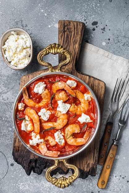 Crevettes cuites au four traditionnel grec saganaki de crevettes avec feta tomate paprika et thym Fond gris Vue de dessus