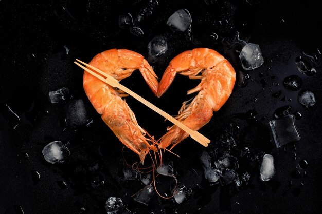 Crevettes cuites en forme de coeur de crevettes sur fond de pierre avec vue de dessus de glaceCélébration de la Saint-Valentin