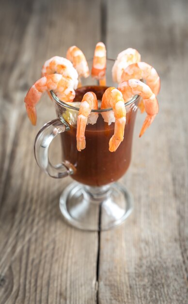 Crevettes cuites à la sauce tomate sur la table en bois