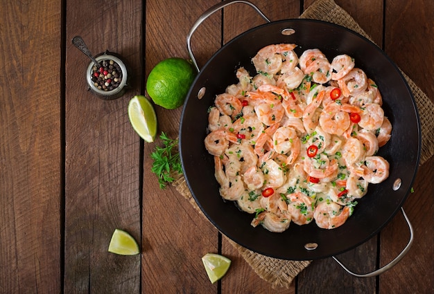 Crevettes dans une sauce à l&#39;ail crémeuse au persil et à la citron vert dans une poêle à frire. Vue de dessus