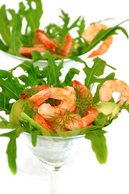 Crevettes dans un verre avec avocat et roquette close