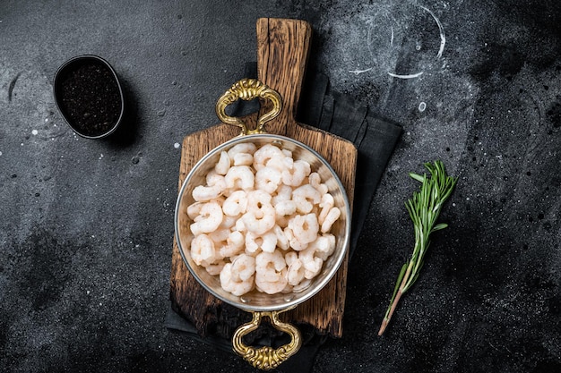 Crevettes décortiquées bouillies cuites dans une poêle Vue de dessus sur fond noir