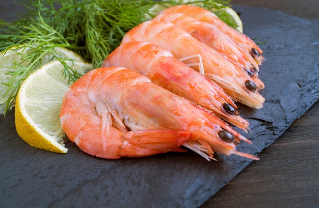 Crevettes fraîchement bouillies empilées sur une planche.