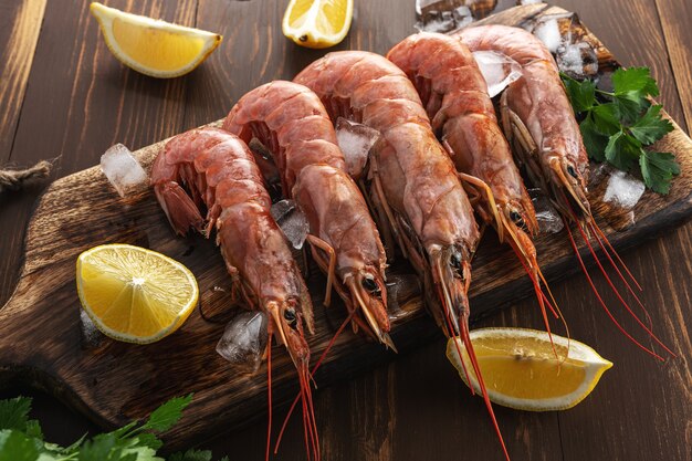 Crevettes fraîches sur bois avec tranche de citron.