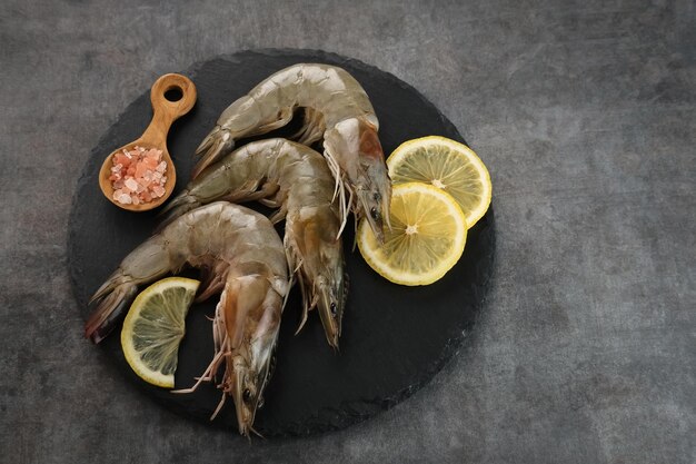 Crevettes fraîches servies sur une planche à découper avec un fond sombre Préparation des aliments