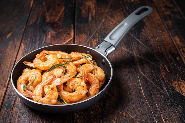 Crevettes frites au beurre et à l'ail Crevettes dans une poêle Fond en bois Vue de dessus