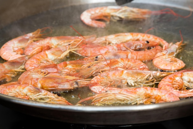 Crevettes frites dans la poêle préparant la paella