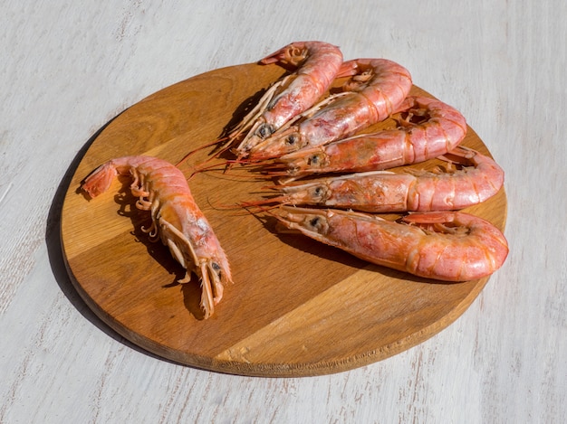 Crevettes géantes fraîches cuites sur une planche à découper en bois