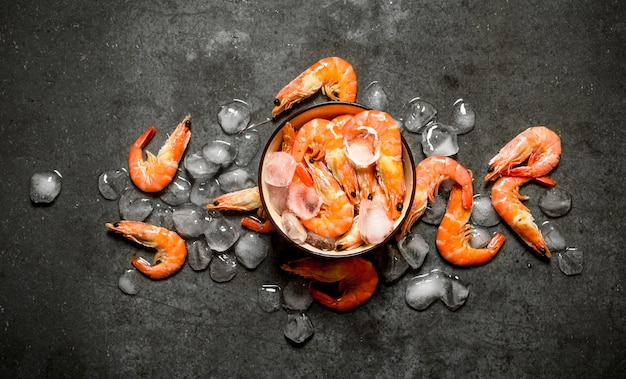 Crevettes avec de la glace dans un bol sur pierre.