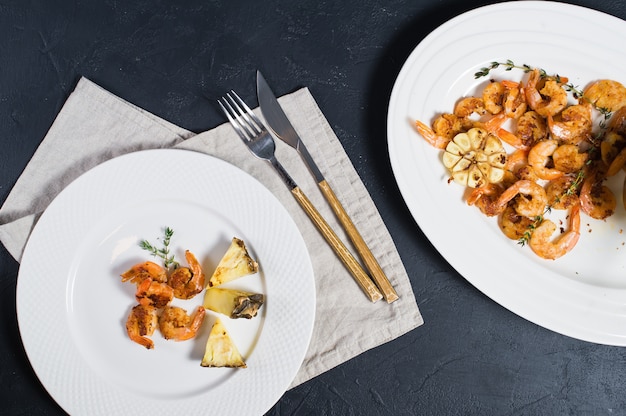 Crevettes grillées sur une assiette blanche à l&#39;ananas.